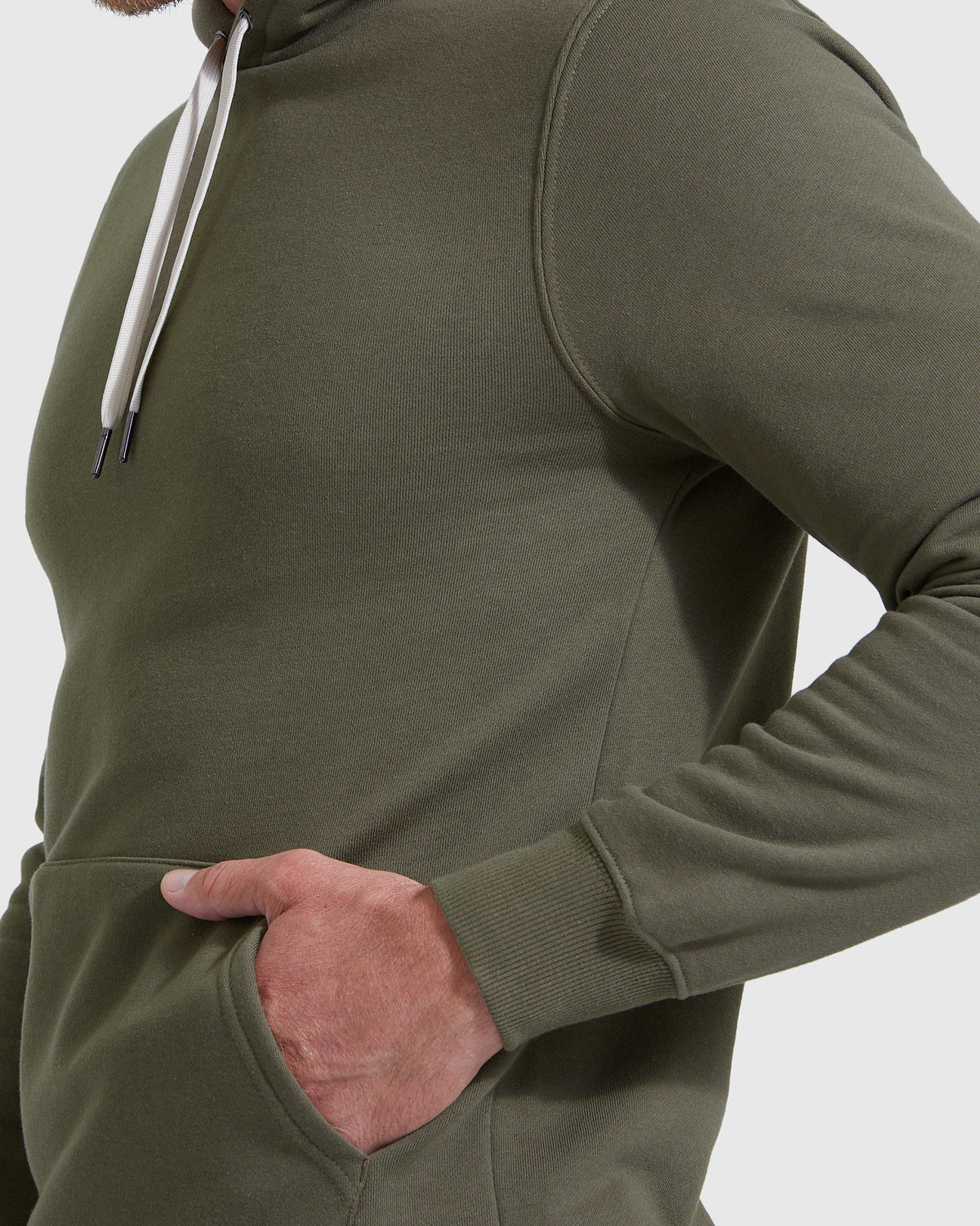 Wearing Military Green Fleece French Terry Pullover Hoodie, hand in pocket.