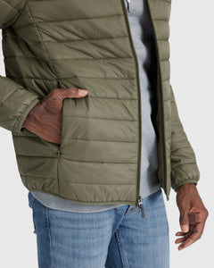True ClassicMilitary Green Puffer Jacket over gray sweatshirt and blue jeans.