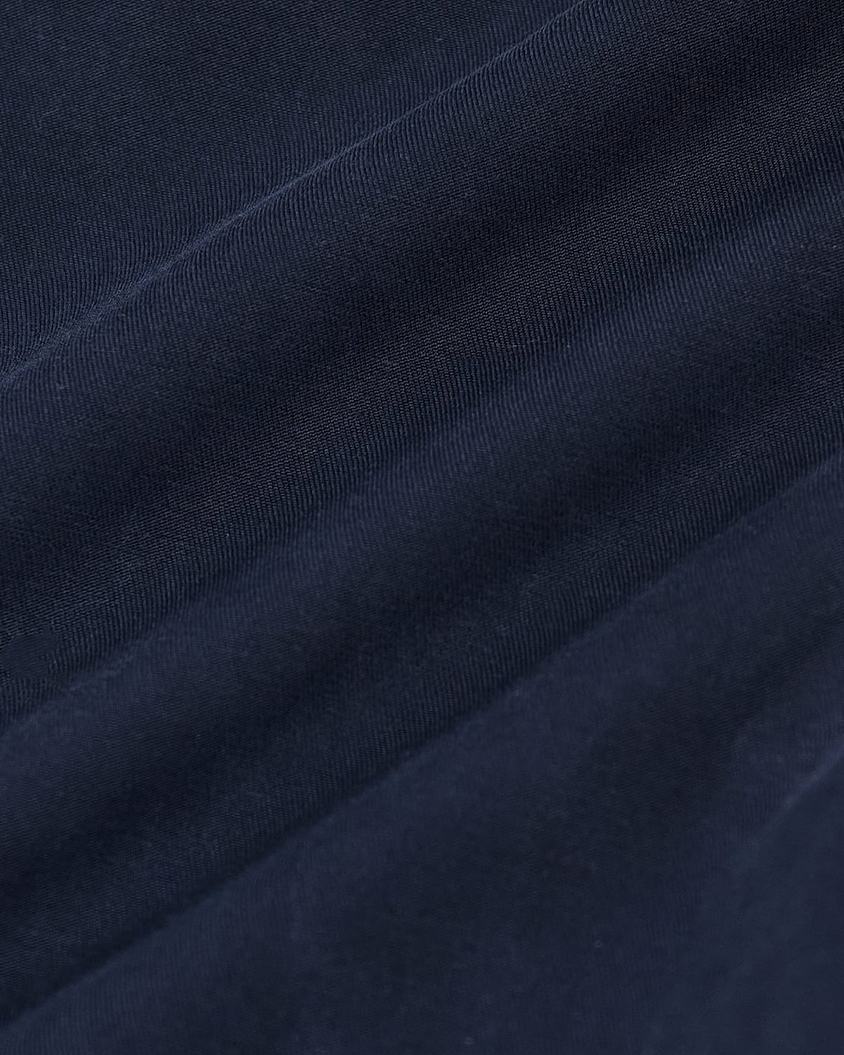 Navy Bomber Jacket fabric detail with visible weave and creases.