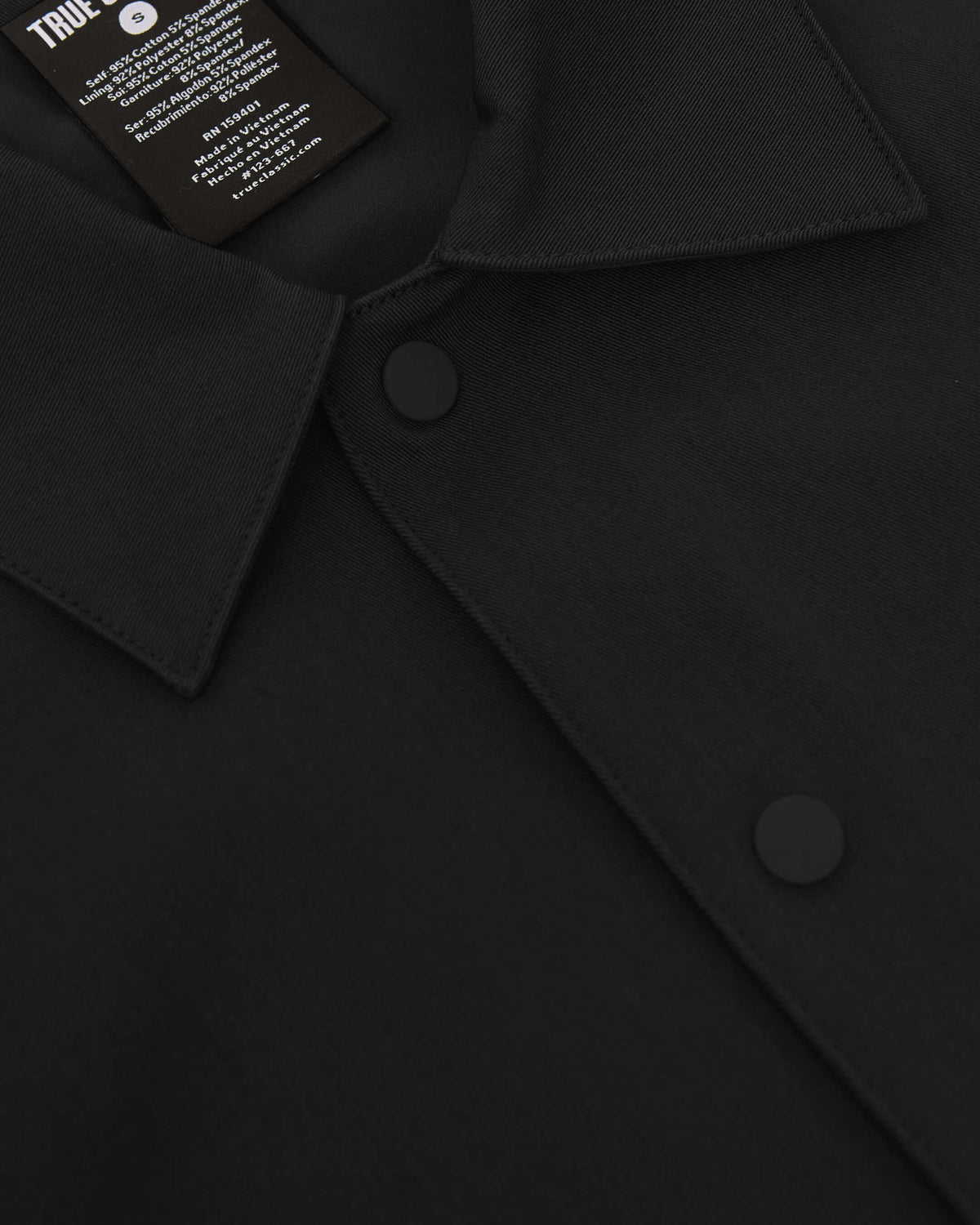 Black Coaches Jacket with snap buttons, pointed collar, and visible interior tag.