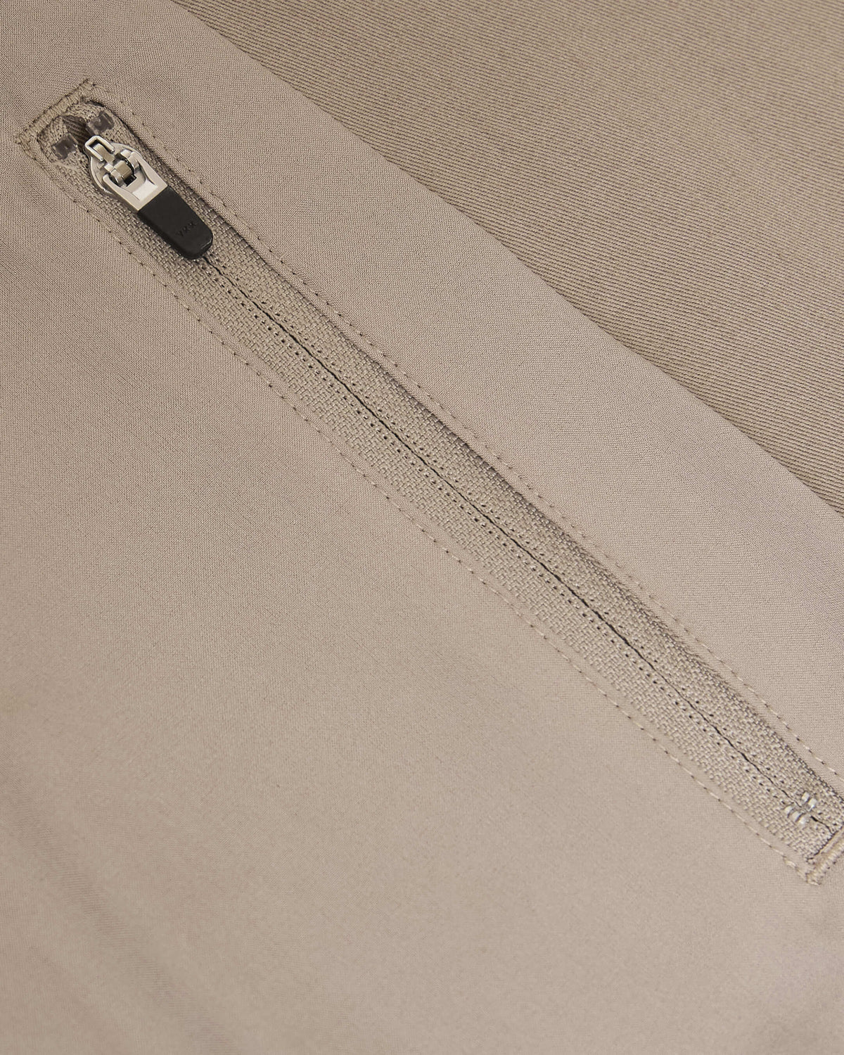 Khaki Coaches Jacket zipper detail on beige twill fabric.