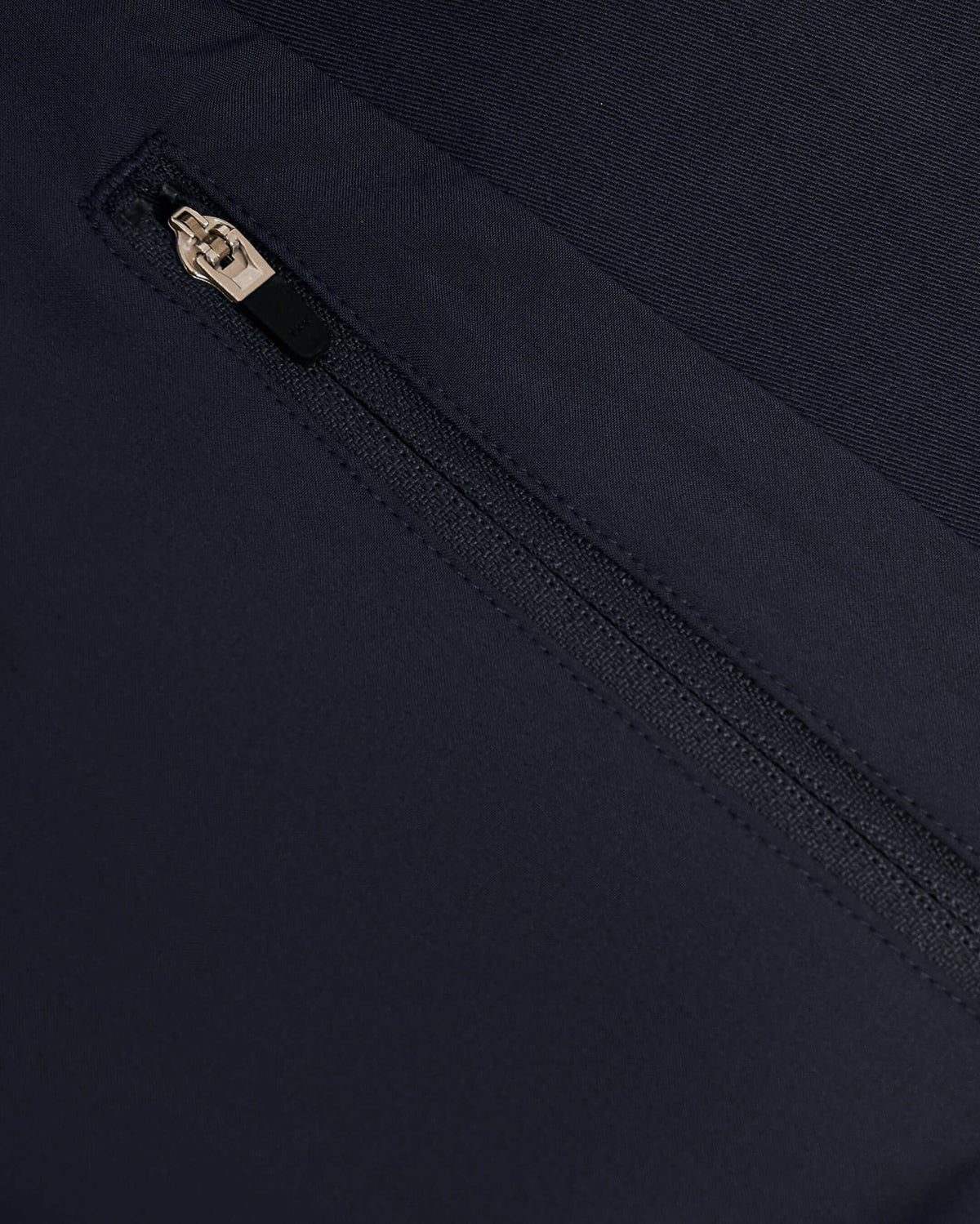 Navy Coaches Jacket with diagonal zipper on fabric panel.