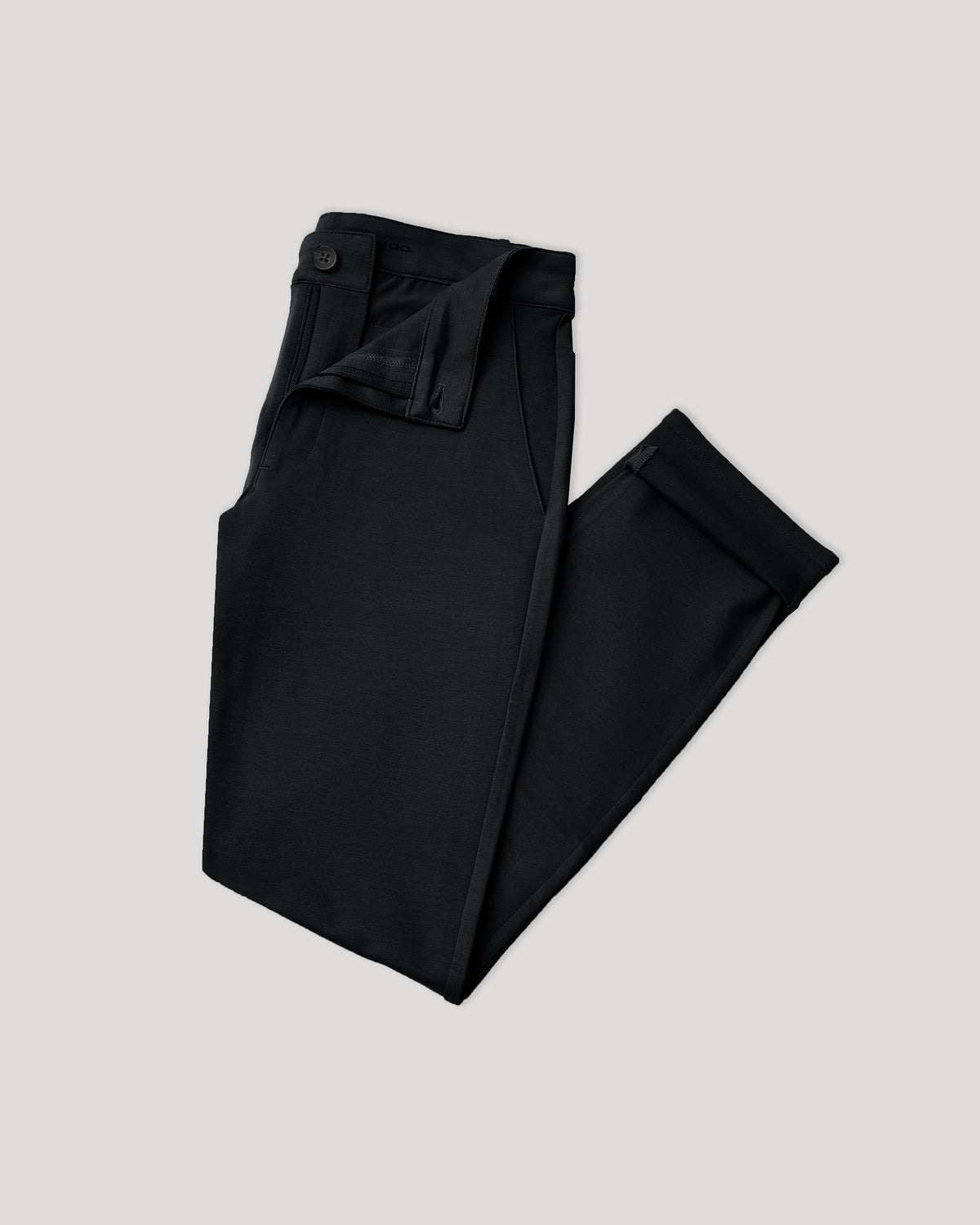 Black Slim Comfort Knit Chino Pant laid flat, partially open fly.