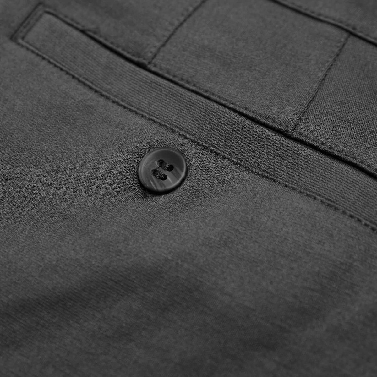 Close-up of Carbon Slim Comfort Knit Chino Pant welt pocket and button.