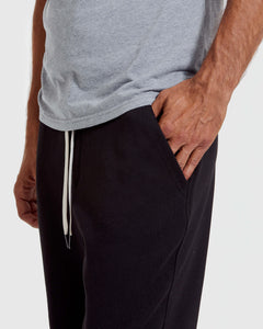 True ClassicBlack Fleece French Terry Joggers with white drawstring, hand in pocket.