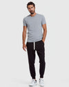 Man wearing Black Fleece French Terry Joggers with white sneakers.