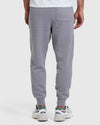 Back view of a man wearing Heather Gray Fleece French Terry Joggers paired with white sneakers, showcasing the joggers' relaxed fit and single back pocket.