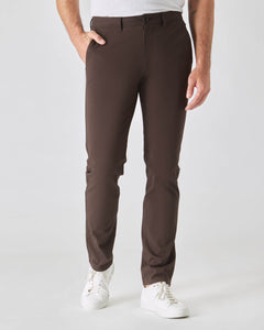 True ClassicDark Oak Slim Twill Chino Pant with white sneakers, studio setting.