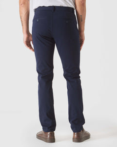 True ClassicNavy Slim Twill Chino Pant shown from the back with sneakers.