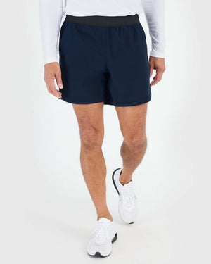 7 Navy Active Training Short on person walking, showcasing athletic fit.