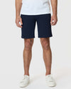 Navy Twill Short with white sneakers, tattoos visible on hands and knees.