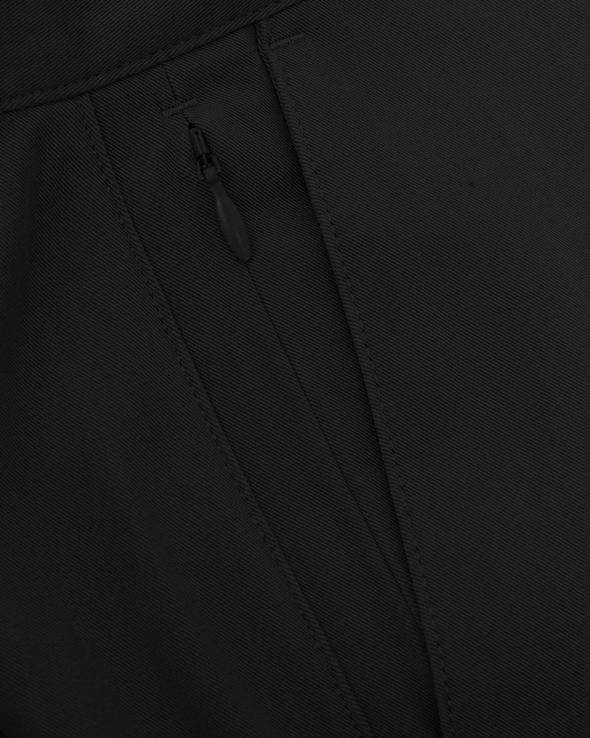 7 Black Classic Twill Shorts, close-up of seam and zippered pocket.