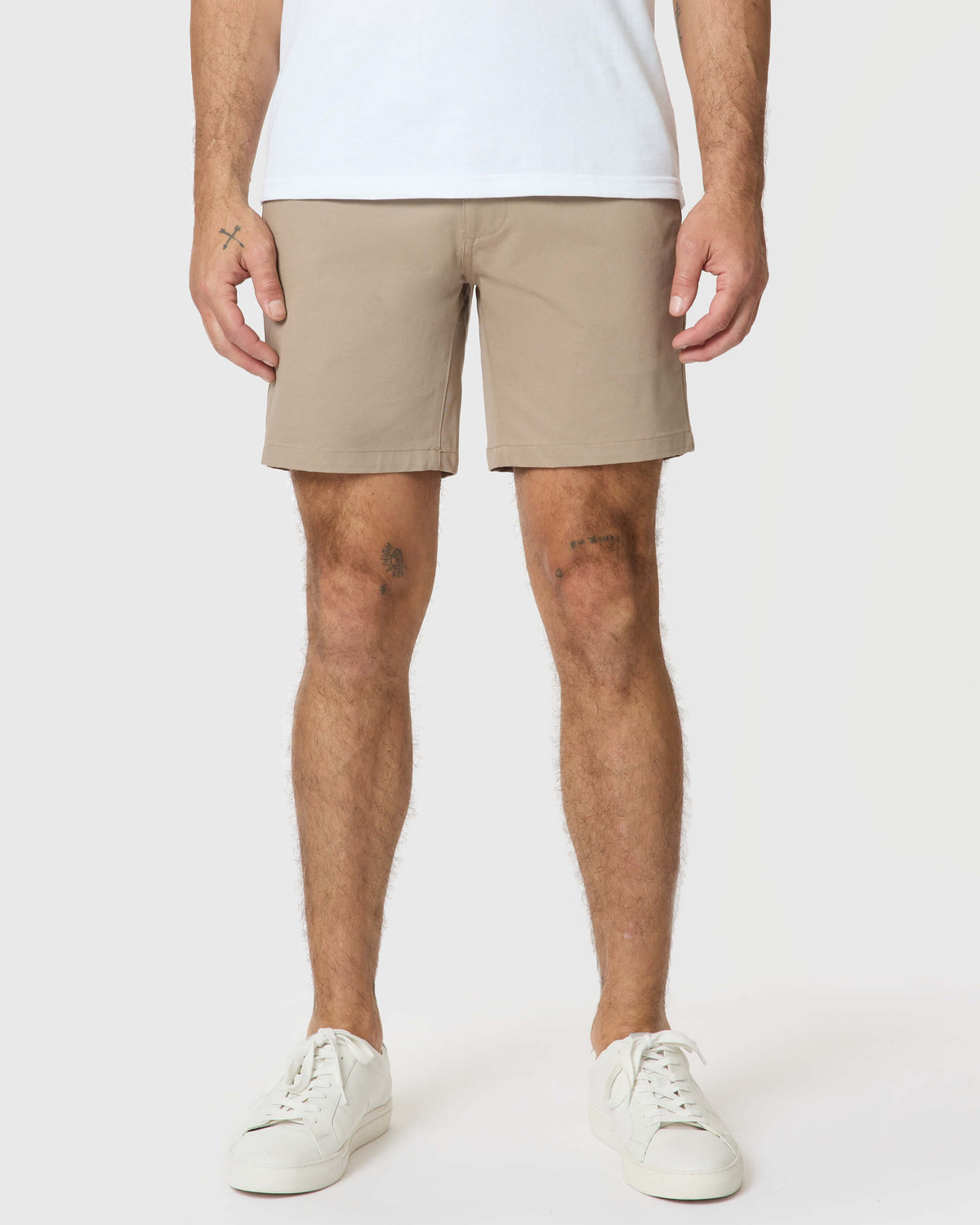 7 Khaki Classic Twill Shorts with white sneakers and visible tattoos.