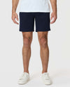 Model wearing 7 Navy Classic Twill Shorts with white sneakers.