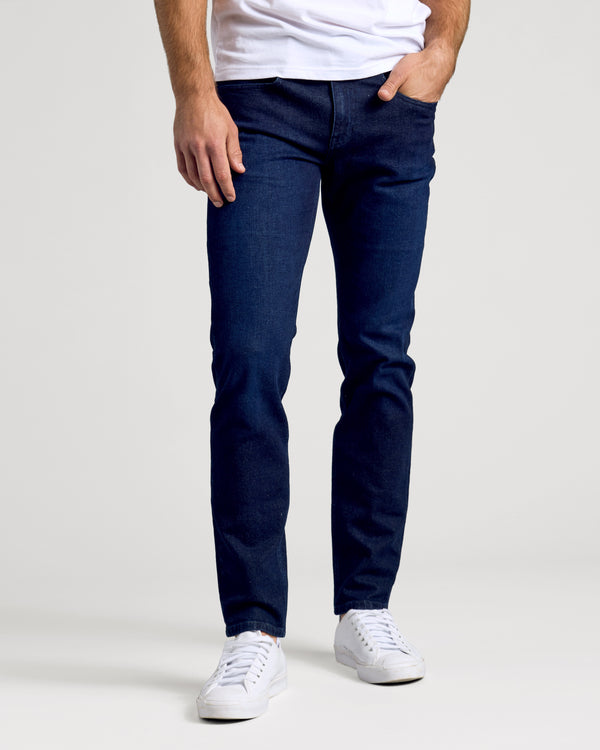 Indigo Rinse Slim Authentic Denim Jeans modeled with white sneakers.
