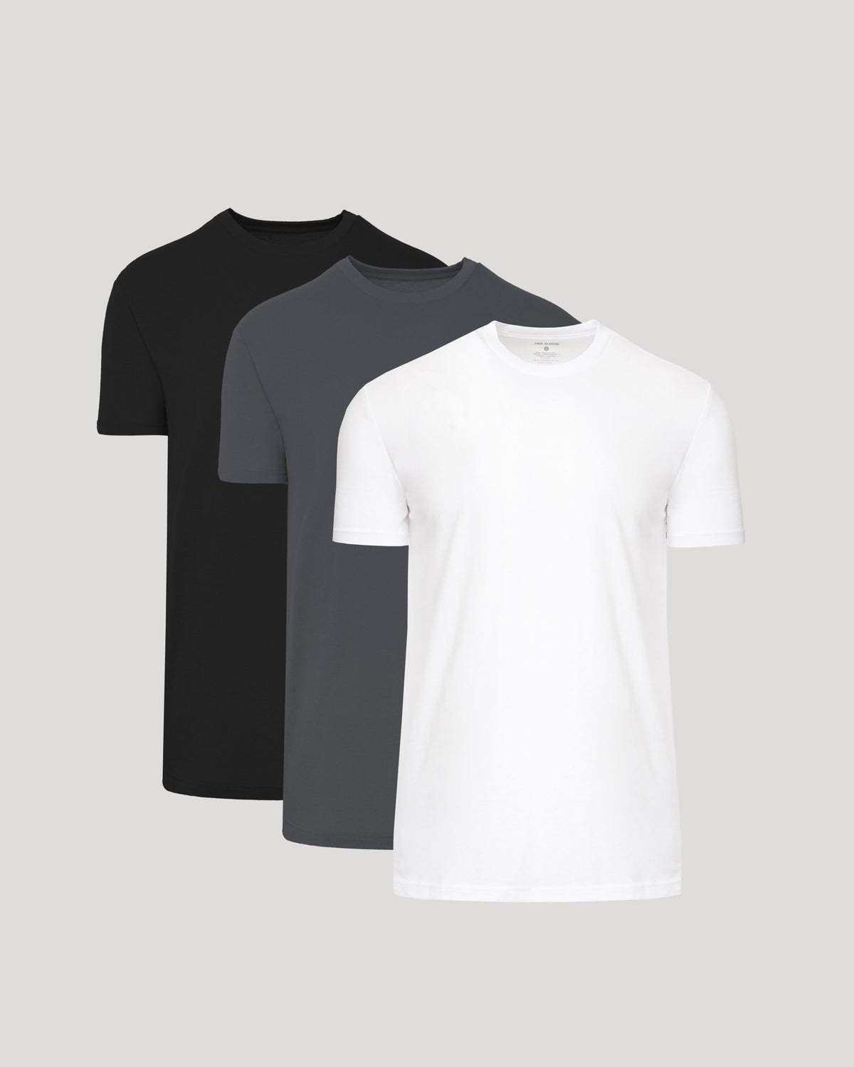 Black, dark gray, and white crew neck t-shirts with tall straight hems, short sleeves.