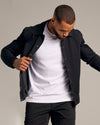 Man adjusting Black Coaches Jacket with snap buttons.