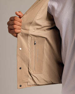 True ClassicPerson opening Khaki Coaches Jacket to reveal interior zip pocket.