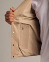 Person opening Khaki Coaches Jacket to reveal interior zip pocket.