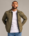 Man in Military Green Coaches Jacket over white T-shirt.