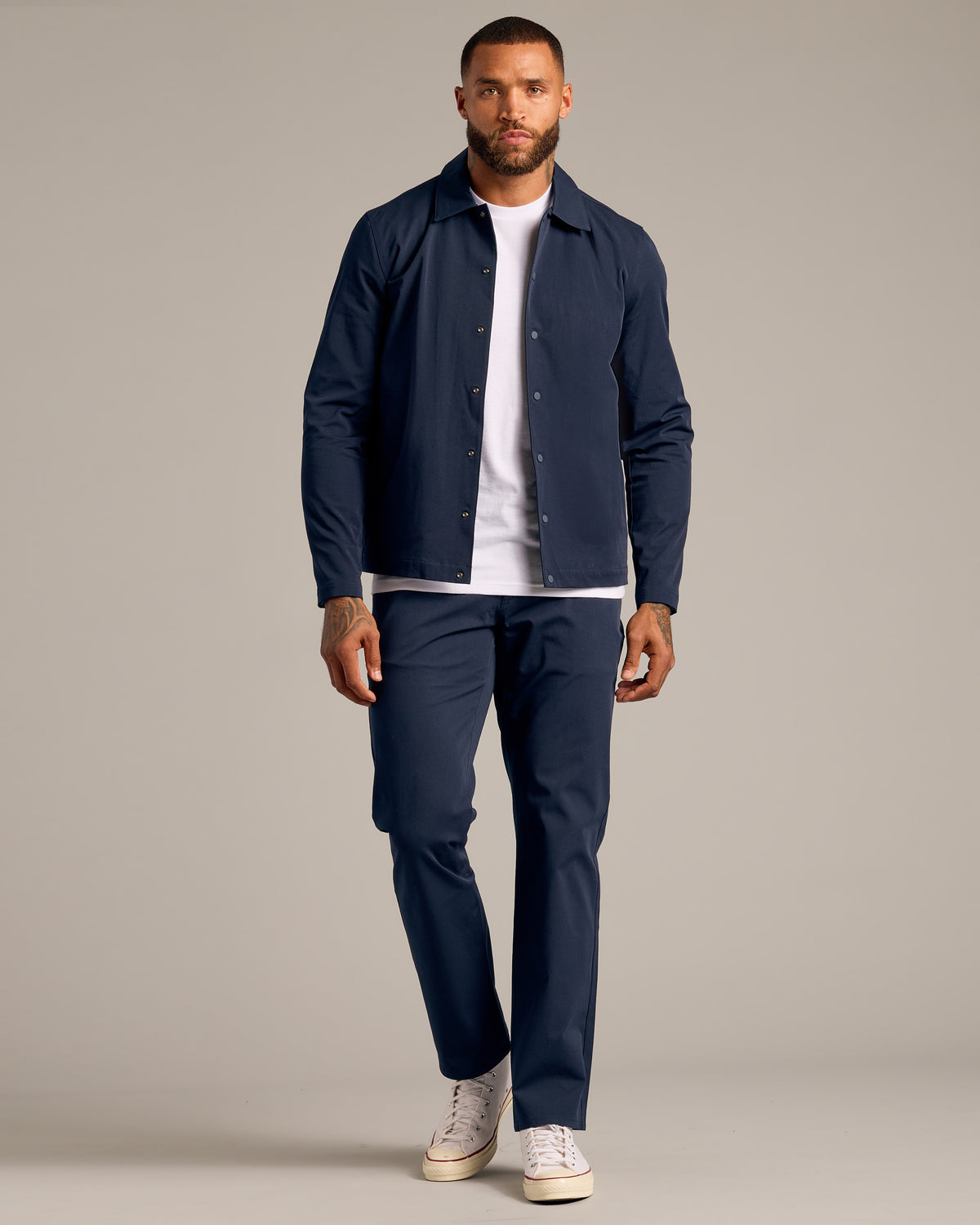 Man wearing Navy Coaches Jacket, showcasing its slim fit and style.