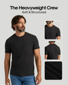 A man wearing a plain black short-sleeve crew-neck T-shirt is shown against a light gray background, with the text 'The Heavyweight Crew Soft & Structured' above him and three inset views on the right showing the front, back, and fabric texture.