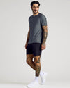 Man wearing Carbon Active Crew Neck Tee, black shorts, white socks, running shoes.