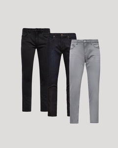 True ClassicThree pairs of men's Slim Comfort Stretch Jeans 3-Pack in black, dark blue, and light grey, displayed against a plain background showcasing a modern slim fit style.
