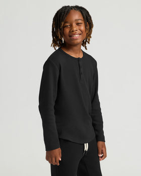 Child wearing Boys' Waffle Long Sleeve Henley 3-Pack, black, with relaxed pose.