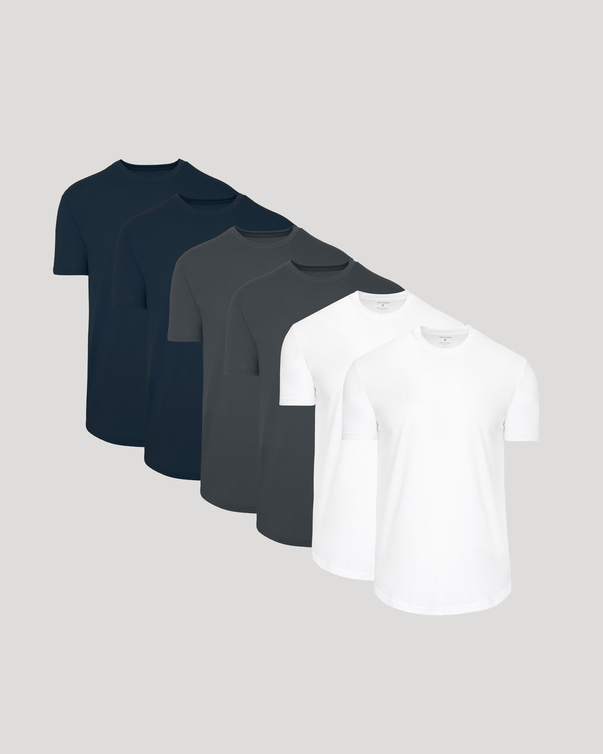 Three dark blue, one black, and two white t-shirts on a light gray background