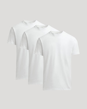 Three white t-shirts stacked on a light gray background
