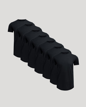 Seven black crew neck t-shirts arranged in a staggered row, showcasing the Tall Pima Cotton Blend Curved Hem Crew 7-Pack, designed as men's basics with a comfortable fit.