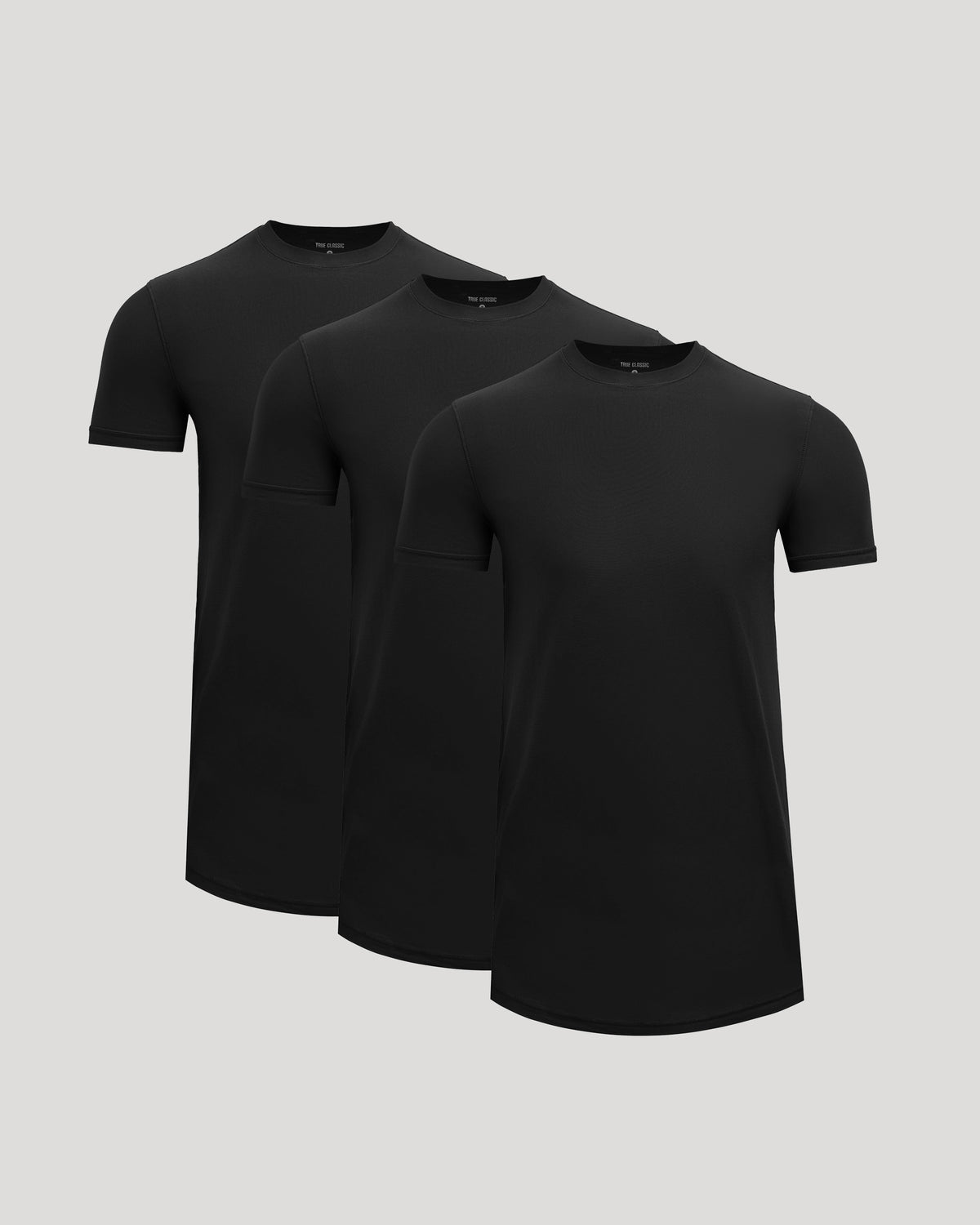 Three black t-shirts stacked on a light gray background