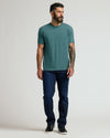 Man wearing Heather Seafarer Classic Crew Neck, dark jeans, and sneakers.