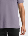 Person wearing a Dark Heather Amethyst Short Sleeve Polo with a fitted cut.