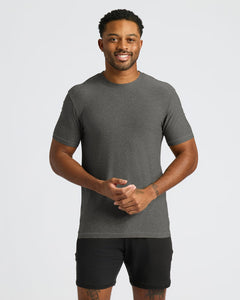 True ClassicA man wearing a dark gray short-sleeve crewneck athletic t-shirt and black athletic shorts, standing against a light gray studio background.