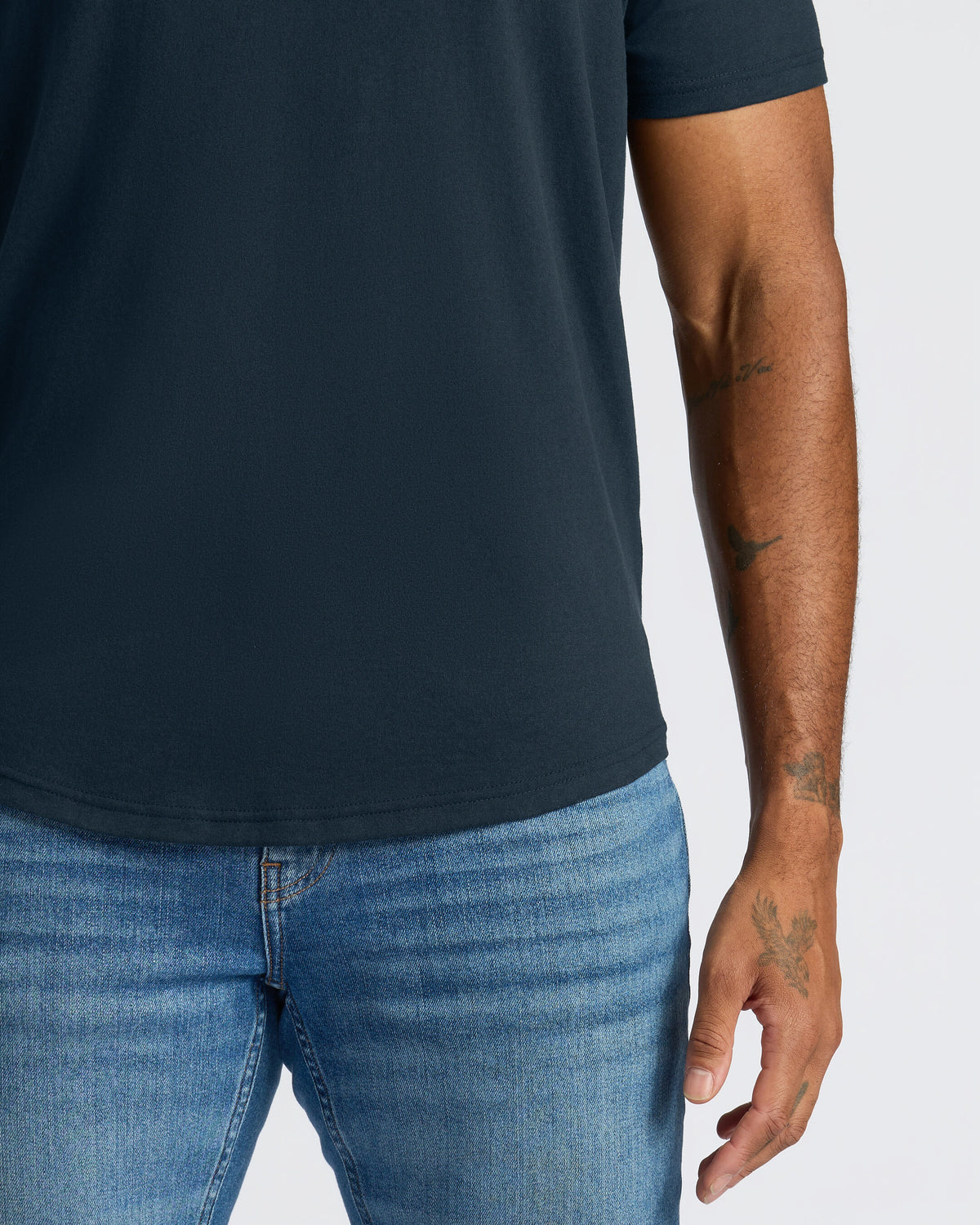 Navy Curved Hem Classic Crew Neck on person with tattooed arm.