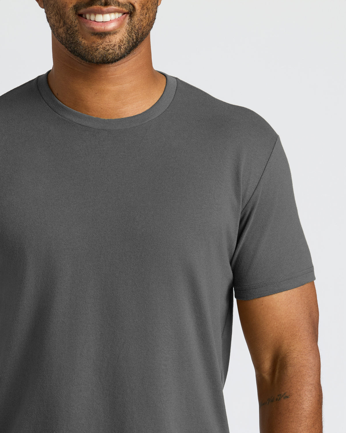 Man wearing a gray t-shirt against a plain background