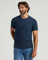 Man wearing a navy blue t-shirt with a pocket on a light gray background