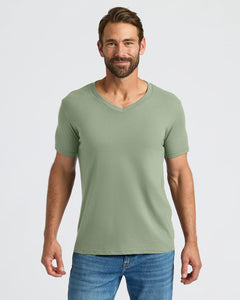 True ClassicMan wearing a green t-shirt and blue jeans on a light gray background