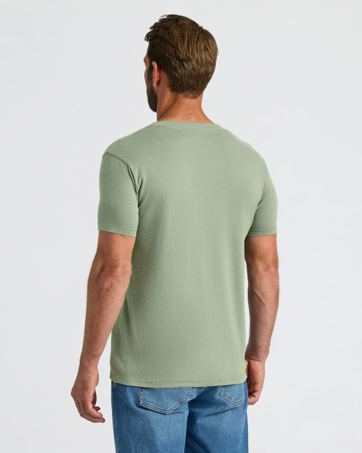 Man wearing a green t-shirt and blue jeans on a white background