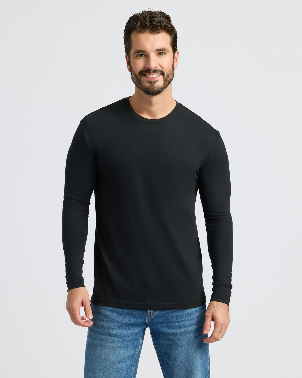 Man wears Black Classic Long Sleeve Crew Neck with blue jeans.