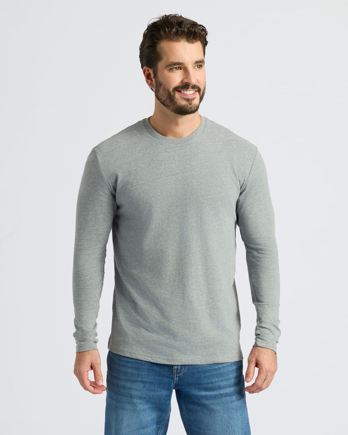 Man wearing Heather Gray Classic Long Sleeve Crew Neck and medium-wash jeans.