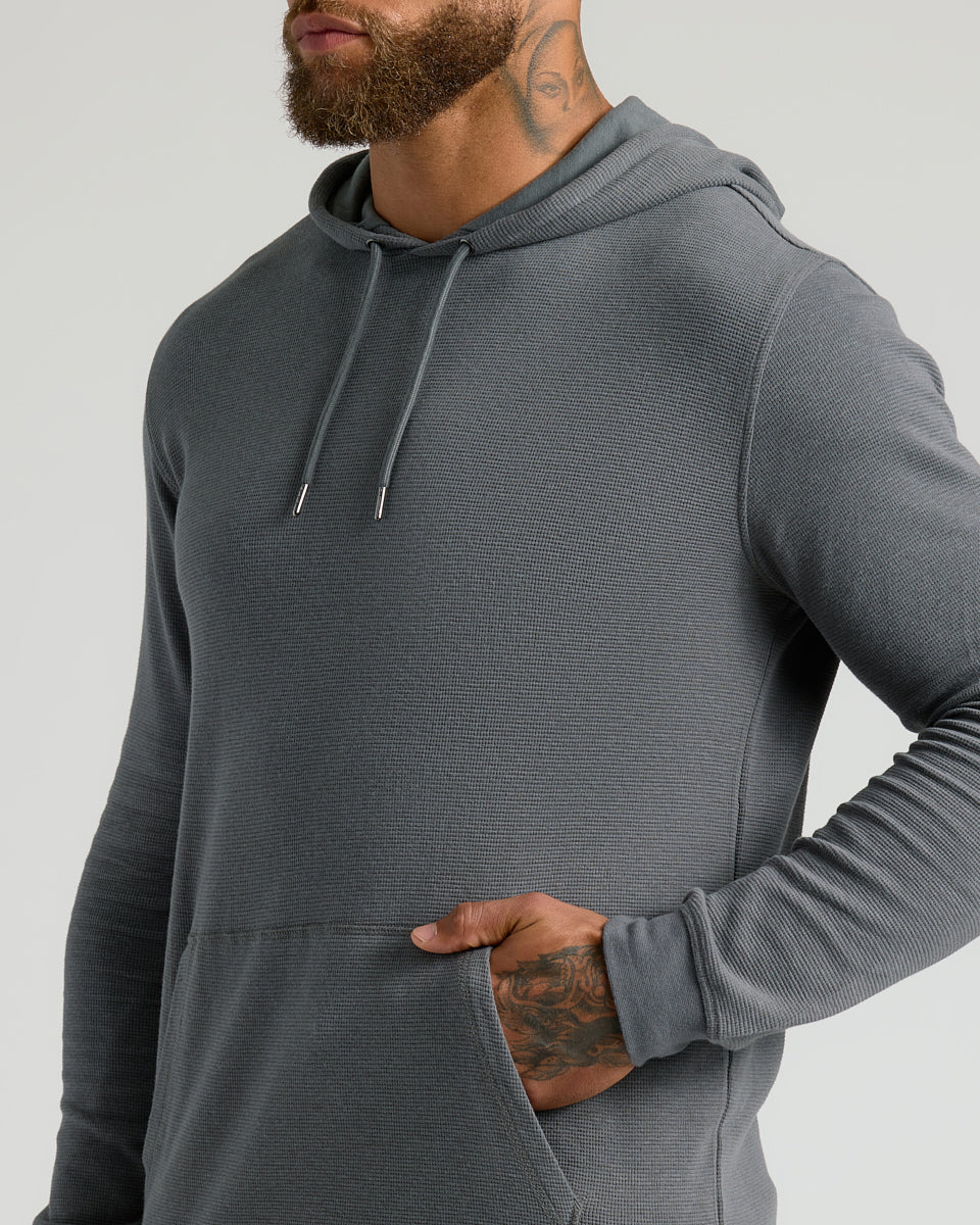 Male model in Carbon Waffle Hoodie with kangaroo pocket.
