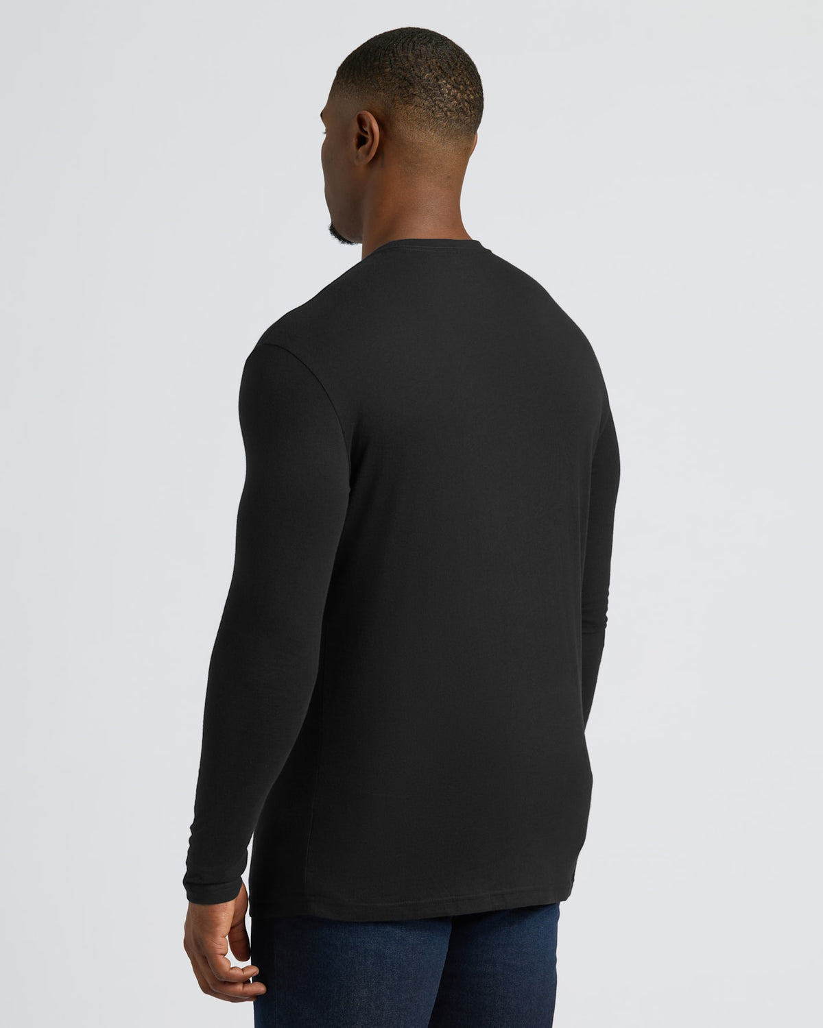 Man in fitted Black Tall Long Sleeve T-Shirt and dark jeans.