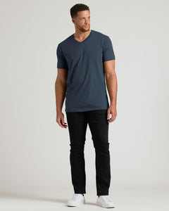 True ClassicMan wearing a navy t-shirt and black pants on a light gray background