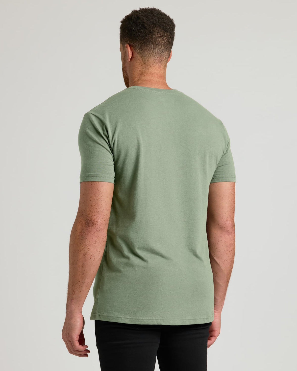 Man wearing a green t-shirt on a plain background