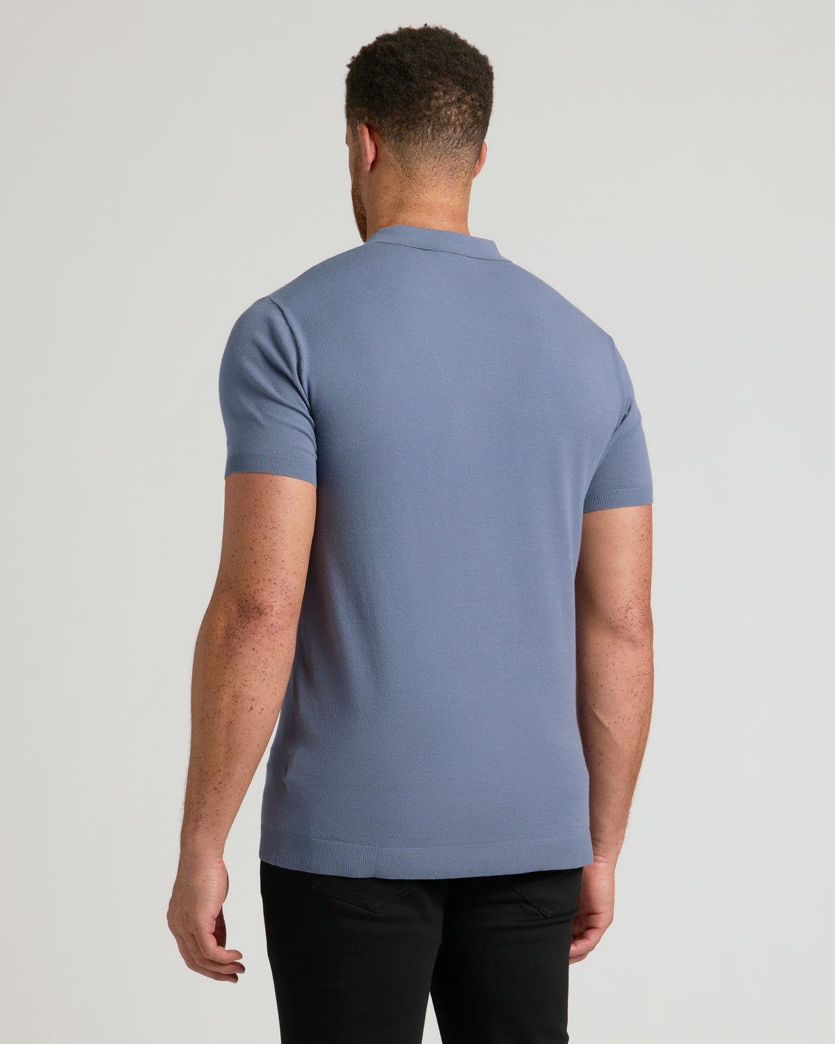 Fiord Tall Dressy Polo, back view on model with slim-fit trousers.
