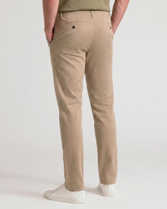 True ClassicA person shown from the back wearing beige corduroy trousers, a green top, and white sneakers against a plain light gray studio background.