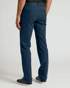 True ClassicNavy Straight Chino Pants 2.0 with black sneakers, studio background.